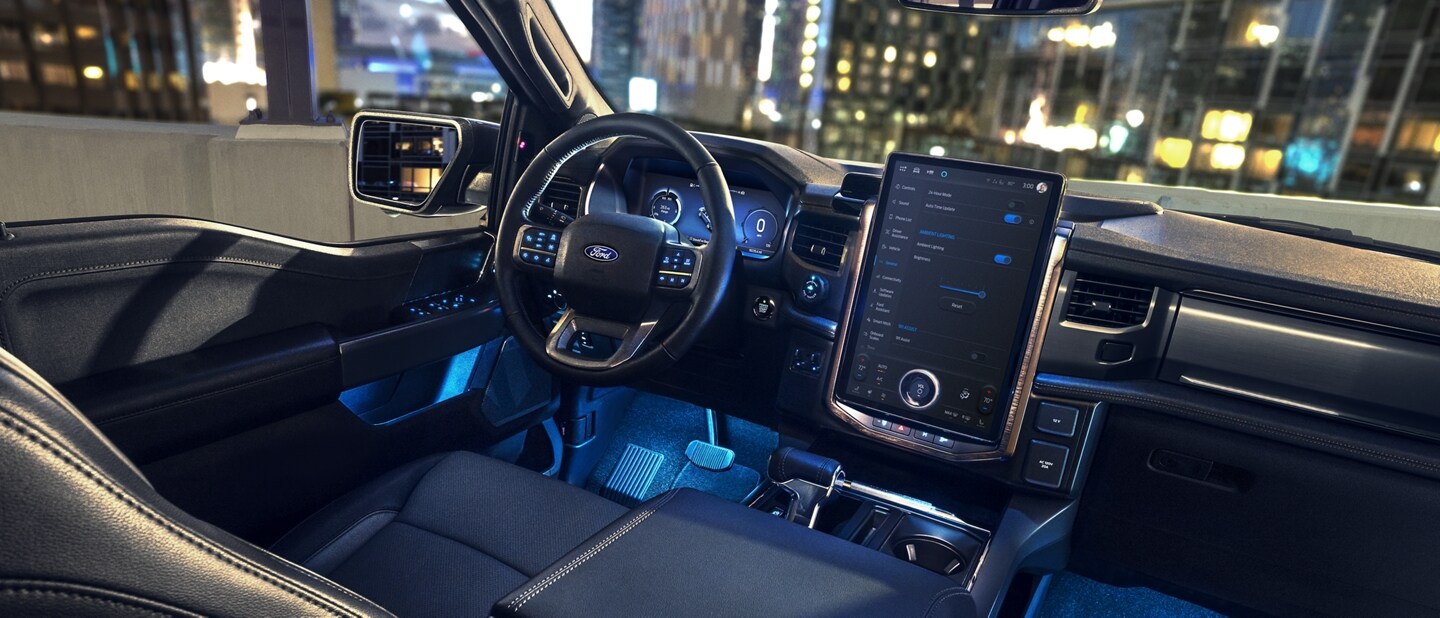 The interior of a 2024 Ford F-150 Lightning® pickup truck at night, with colorful LED illumination in the footwells